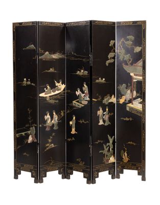 un paravent de style oriental orné de motifs noirs et dorés sur fond blanc