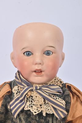 an image of a doll with blue eyes and a bow tie