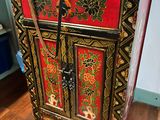 a red and gold cabinet with a black handle on it