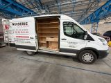 une camionnette blanche garée à l'intérieur d'un bâtiment