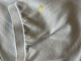 a close up of a white shirt with a yellow spot on it
