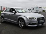the silver audi is parked in a parking lot with a trailer in the background