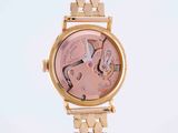 an image of a wrist watch with a pink dial on a gold bracelet