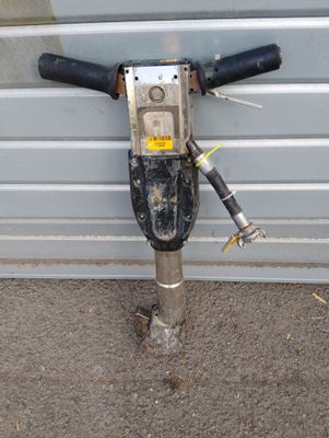 a drill on the ground next to a garage door