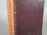 un vieux livre posé sur une table sur une surface grise