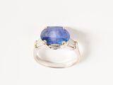 a close up of a blue stone ring on a white surface