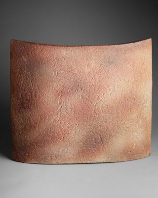 une image représentant un grand vase en argile à la surface incurvée