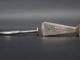 a silver knife and a silver spoon on a table