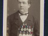 une vieille photo d'un homme en costume, avec des médailles sur la poitrine