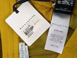 a close up of a yellow shirt with a tag on it