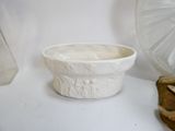un bol blanc posé sur une table à côté d'un vase en verre