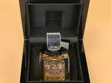 an image of a bottle of perfume in a box on a yellow background
