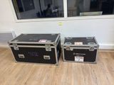 two cases sitting next to each other on a hard wood floor