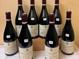 six bottles of wine are lined up in a row on a counter