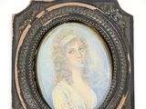 an old picture of a woman in a white dress is hanging on a wall