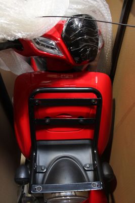 un scooter rouge qui se trouve dans une boîte