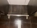 a toilet in a bathroom with a toilet paper dispenser attached to the wall