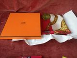 une boîte orange est posée sur un tissu rouge