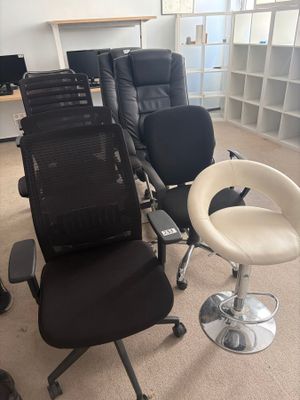 de nombreuses chaises dans une pièce où se trouvent un bureau et une chaise