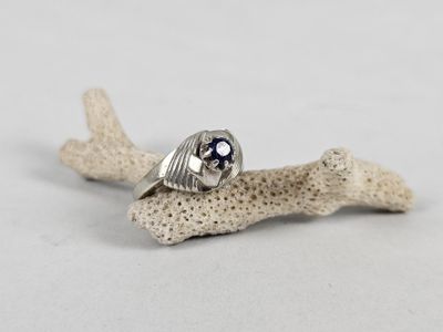 a close up of a silver ring with a blue stone in it