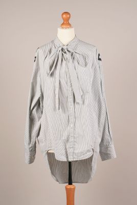 une photo d'une chemise avec un nœud, portée par un mannequin