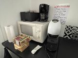a microwave and a coffee maker sitting on a desk