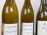 three bottles of wine sitting on a table next to each other
