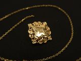 an image of a gold necklace with a heart shaped pendant on it