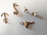trois paires de boucles d'oreilles et un crochet posés sur une surface blanche