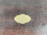 a close up of a piece of wood with a yellow piece of wax on it