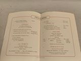 an open book with a menu on it sitting on a table