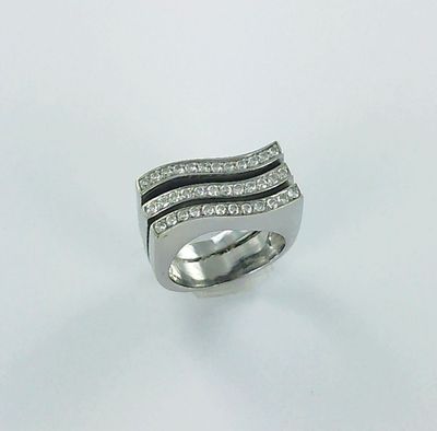 gros plan d'une bague avec des diamants sur une surface blanche