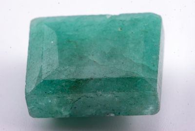 gros plan d'une pierre d'émeraude verte sur une surface blanche