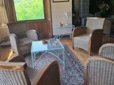 une photo d'un salon avec des fauteuils en osier et une cheminée