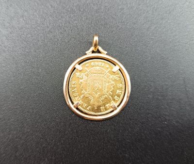 une pièce d'or surmontée d'une couronne, posée sur un fond noir