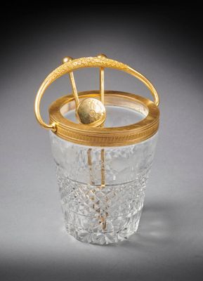 une image représentant un verre muni d'une anse dorée et contenant une boule
