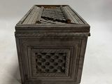 an antique wooden box with a carved design on the lid