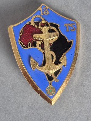 un gros plan d'un insigne doré et bleu sur une surface blanche