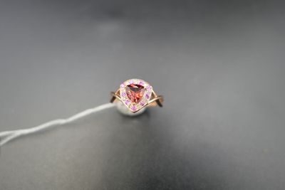 un gros plan d'une bague avec un diamant rose monté sur un fil