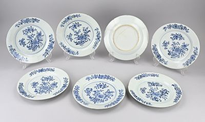six assiettes bleues et blanches ornées de motifs floraux, posées sur une table