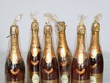 six bottles of champagne are lined up on a marble table
