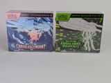 deux boîtes de cartes à collectionner Pokémon posées sur une surface blanche