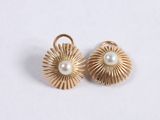 a pair of gold earrings with pearls on a white background