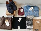 several pairs of men ' s pants and shoes are laid out on a table