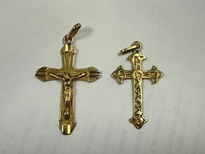 two gold crosses on a white surface with a cross in the middle