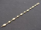 a close up of a gold chain with pearls on it