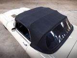 a white car with a black top parked in a parking lot