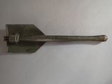 a metal shovel with a long handle on a white surface