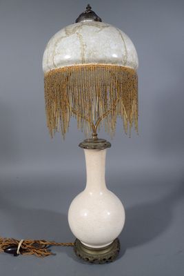 une photo d'une lampe de table avec un abat-jour blanc orné de franges