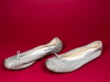 a pair of silver ballet shoes on a red background